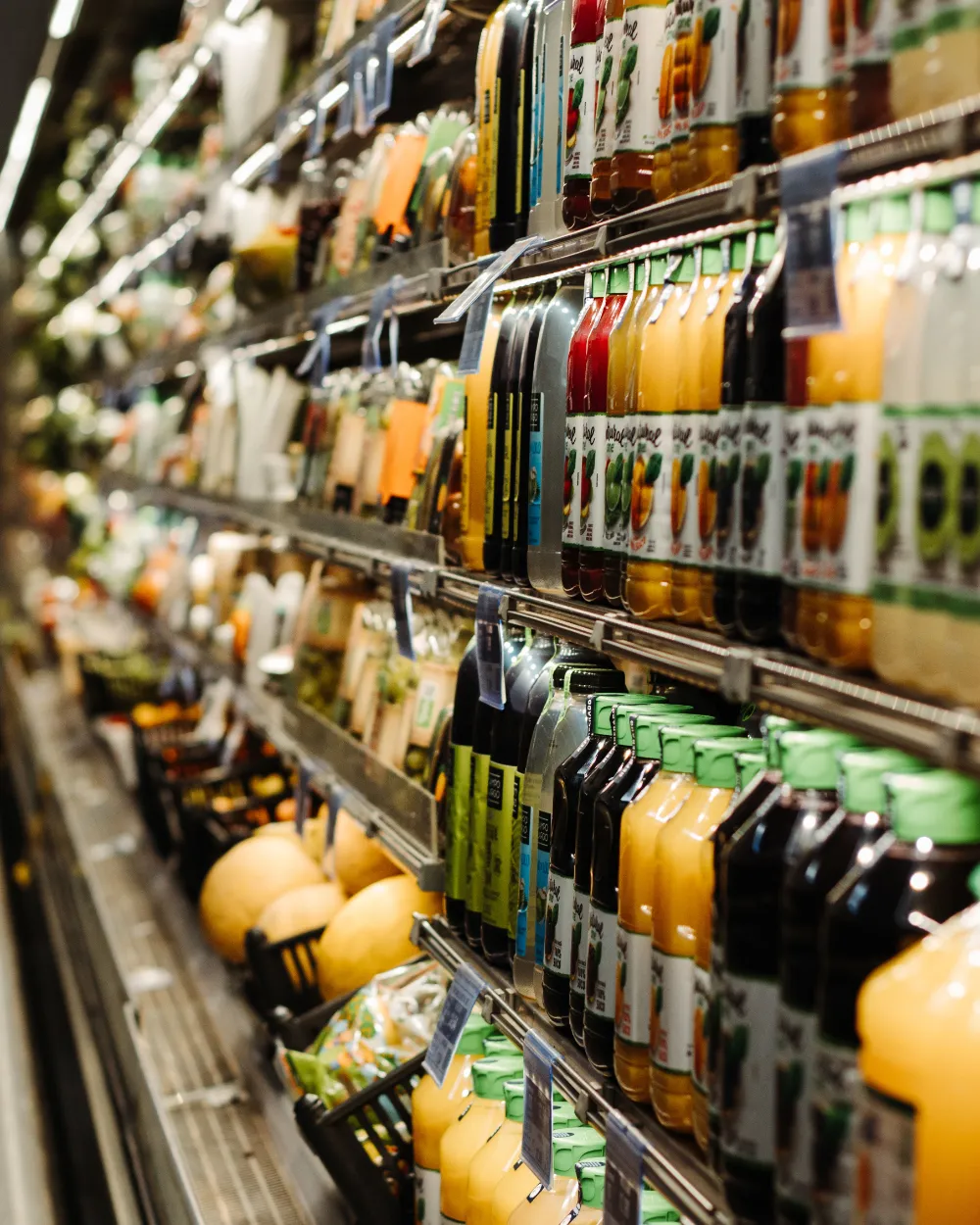 Anaqueles con jugos, bebidas y fruta.