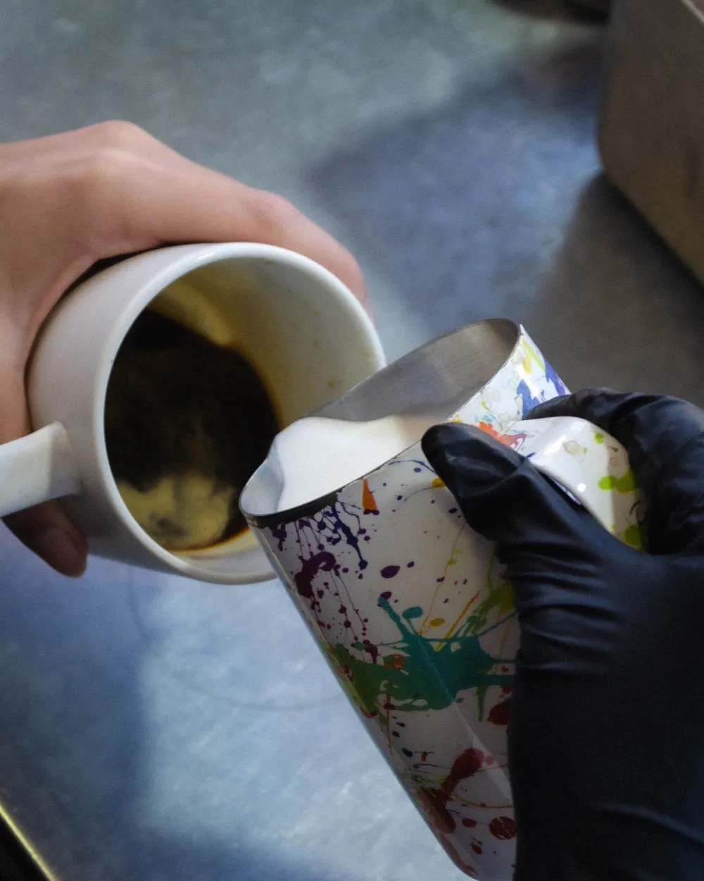 Una barista sirviendo leche en un café.