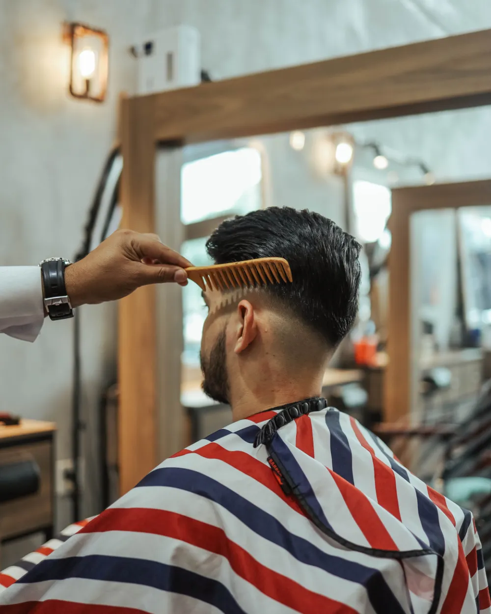 Un barbero peinando a un cliente.