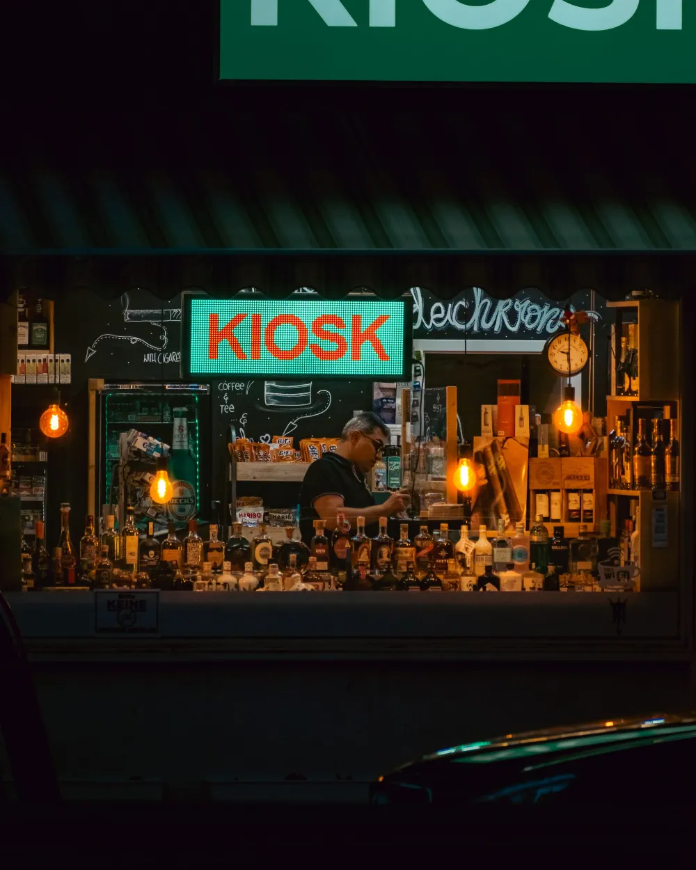 El aparador iluminado de una tienda de vinos y licores.